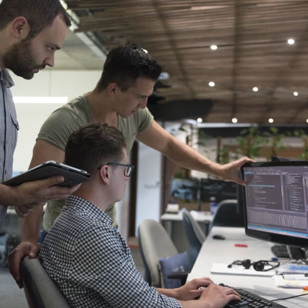 Why Outsourcing Your SOC is a Smart Investment 1 cybersecurity experts at a computer reviewing code