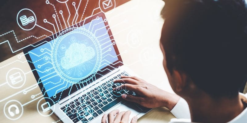 Man sitting at laptop with graphic overlay