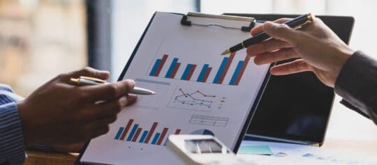 ISO 27001: 5 Key Points for Leadership Teams 2 two people pointing pens at clipboard in a discussion