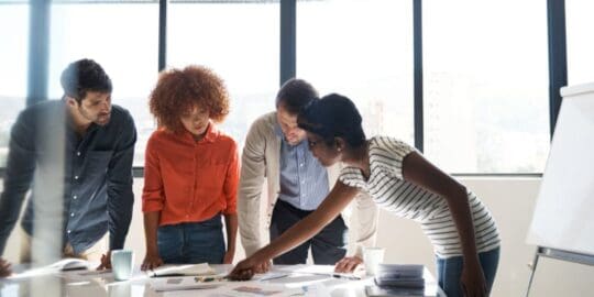 The Importance of Cyber Incident Playbooks 2 Three people around a table looking a documents and pointing
